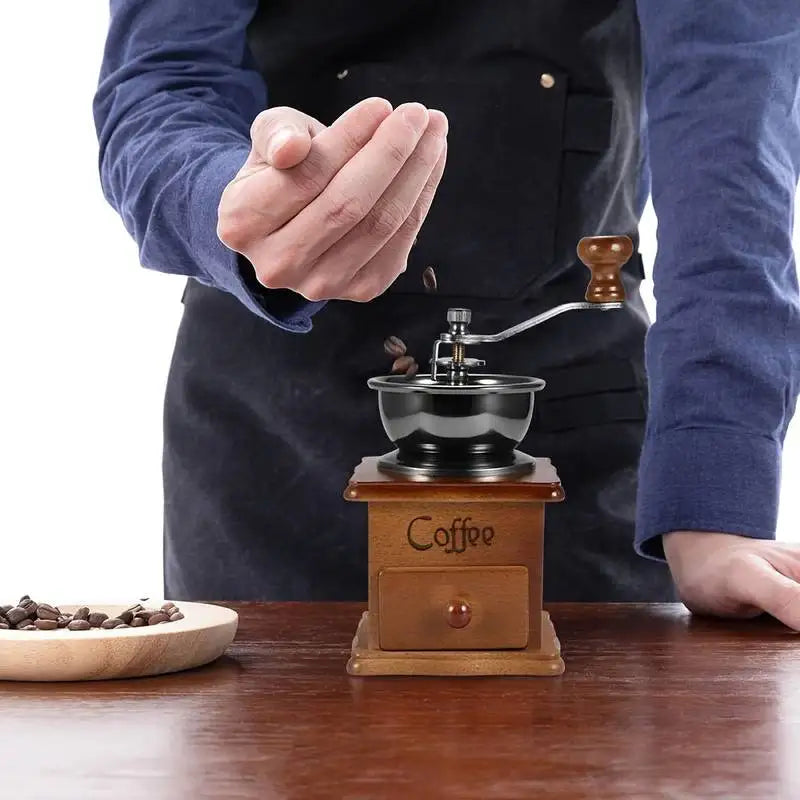 Vintage-style plastic hand-crank coffee grinder in a light brown color, shown from a slight angle wi (view 3)
