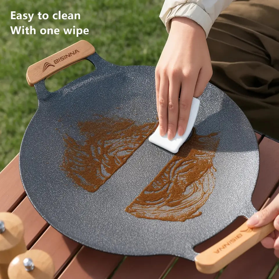 34cm round black aluminum alloy grill pan with a ridged cooking surface, shown on a camp stovetop (view 4)