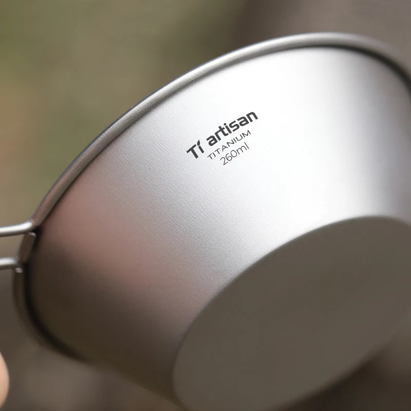 A single 260ml titanium camping bowl with a fixed handle, shown from an overhead angle. (view 5)