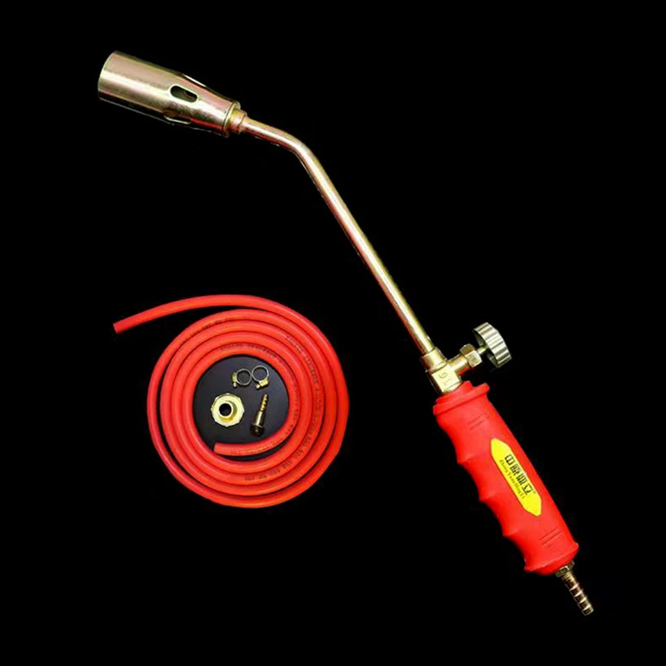 Close-up of a portable manual igniter with a gas hose attachment, shown in an outdoor setting (view 5)