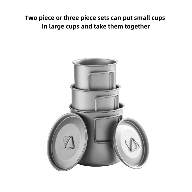 Titanium camping mug with a folding handle, shown in an outdoor setting (view 4)