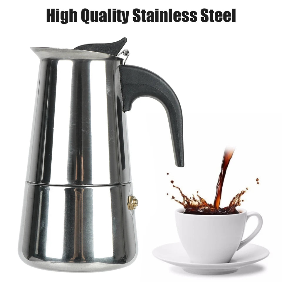 Stainless steel moka pot on a stovetop with coffee pouring into the upper chamber (view 2)